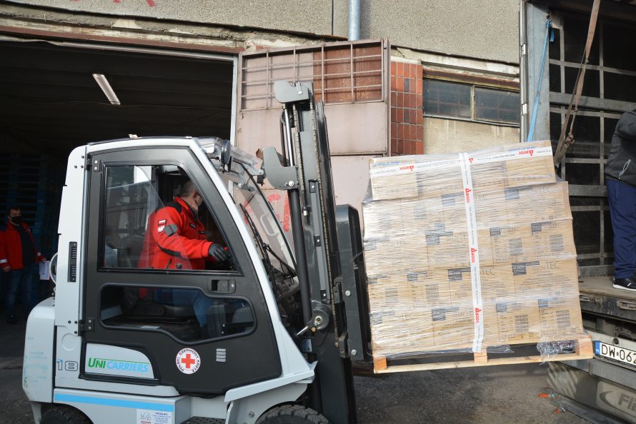 Wózek widłowy z załadowaną paletą.