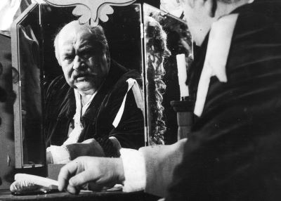 CZarno-białe zdjęcie mężczyzny soedzącego przed lustrem