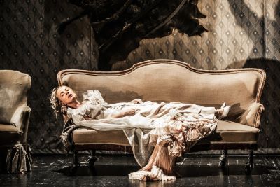 kobieta w kremowej sukni leżąca na kanapie