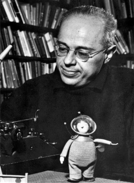 Stanisław Lem przy maszynie do pisania. W tle książki na półkach.