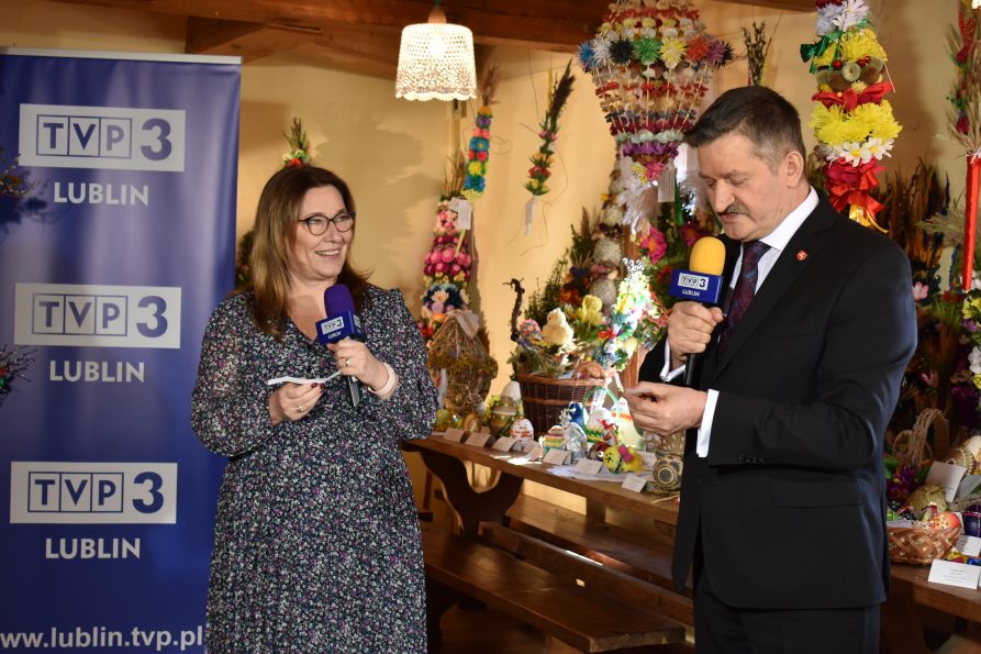 Od lewej europoseł Beata Mazurek z prawej członek zarządu Zdzisław Szwed. w Tle, na stole różne palmy i pisanki