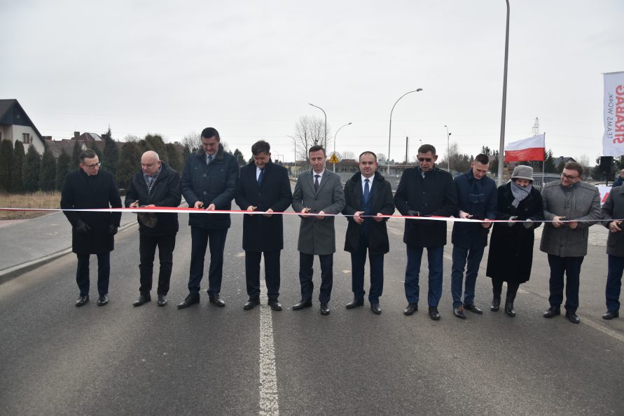 Uroczyste przecięcie wstęgi na drodze nr 837. Przy szarfie stoją przedstawiciele samorządów, wykonawców.
