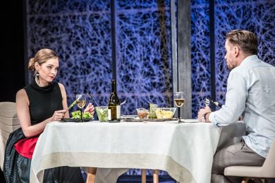 Kobieta i mężczyzna siedzący naprzeciw siebie przy zastawionym stole