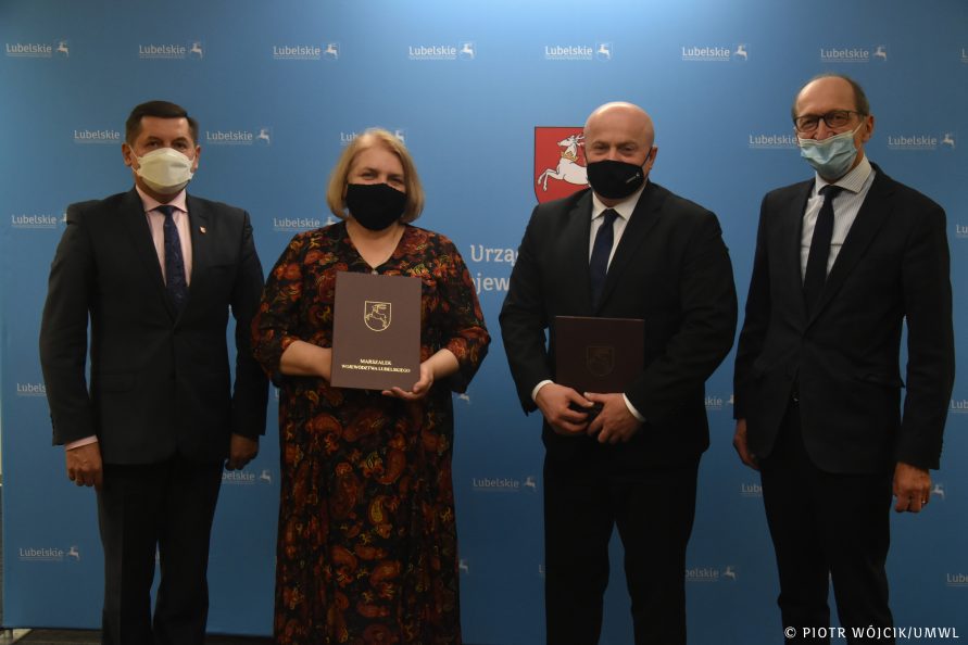 Na tle niebieskiej ścianki z herbem województwa i napisem lubelskie stoją od lewej Janusz Bodziacki dyrektor Departamentu Środowiska i Zasobów Naturalnych, Ewa Zybała Starosta Lubartowski, Jarosław Stawiarski Marszałek Województwa Lubelskiego, Lucjan Mileszczyk Wicestarosta Lubartowski
