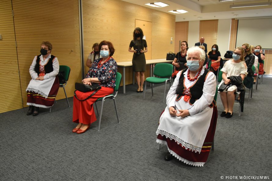 Na krzesłach, z zachowaniem odstępu siedzą laureatki konkursu. Część z nich ubrana jest tradycyjne stroje ludowe