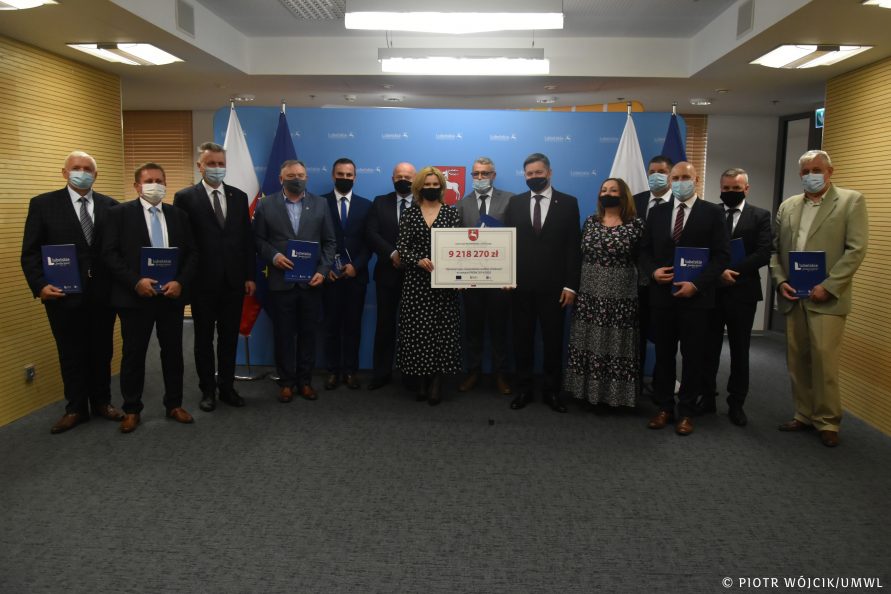 Grupowe zdjęcie beneficjentów z marszałkiem Stawiarskim i członkiem zarządu Szwedem