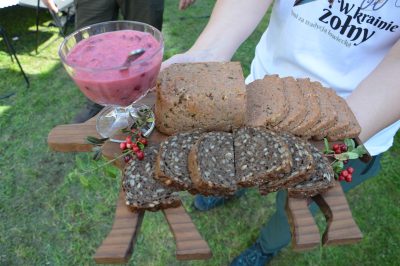 Danie zaprezentowane na drewnianej desce przystrojone czerwonymi jagodami