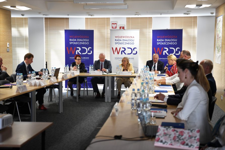 Członkowie Prezydium siedzą przy stole i prowadzą dyskusję. W centrum pomiędzy zebranymi siedzi Marszałek Województwa Lubelskiego Jarosław Stawiarski