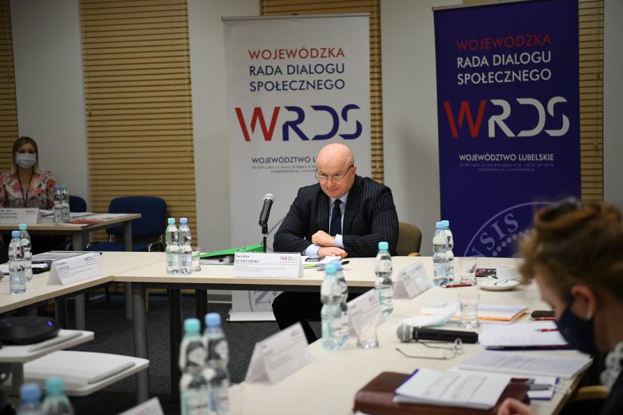 Zdjęcie przedstawiające Marszałka Województwa Lubelskiego Jarosława Stawiarskiego siedzącego przy stole przed mikrofonem.