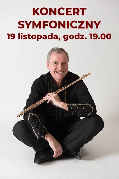 uśmiechnięty mężczyzna ubrany na czarno trzymający flet poprzeczny