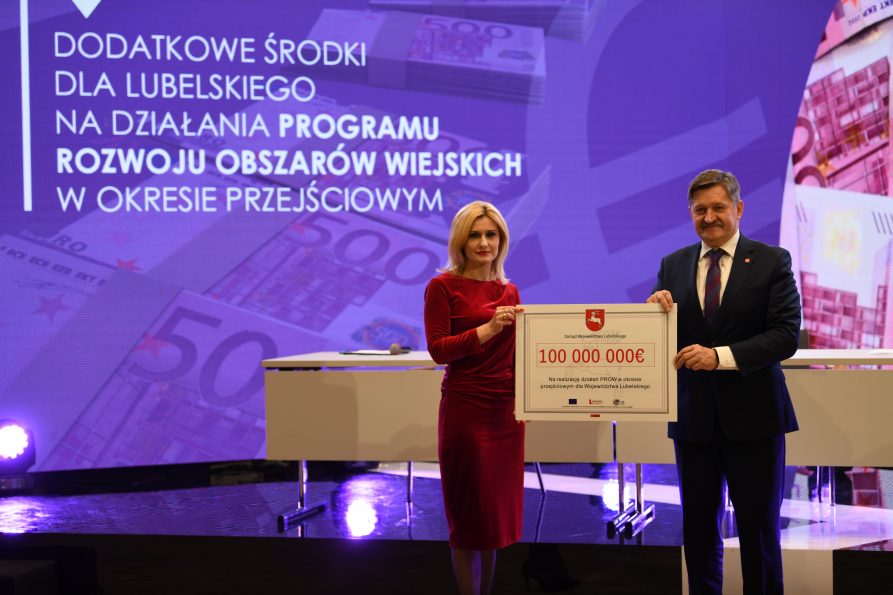Zdjęcie przedstawia dwie osoby kobietę i mężczyznę - Członka Zarządu Zdzisława Szweda , oboje trzymają symboliczny czek ze środkami na Program Rozwoju Obszarów Wiejskich