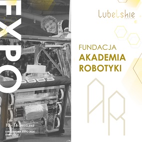 Zdjęcie przedstawiające młodego chłopaka w okularach, który usmiecha się i jest w trakcie pracy tworzy jakieś urządzenie mechaniczne w tle napis Fundacja Akademia Robotyki