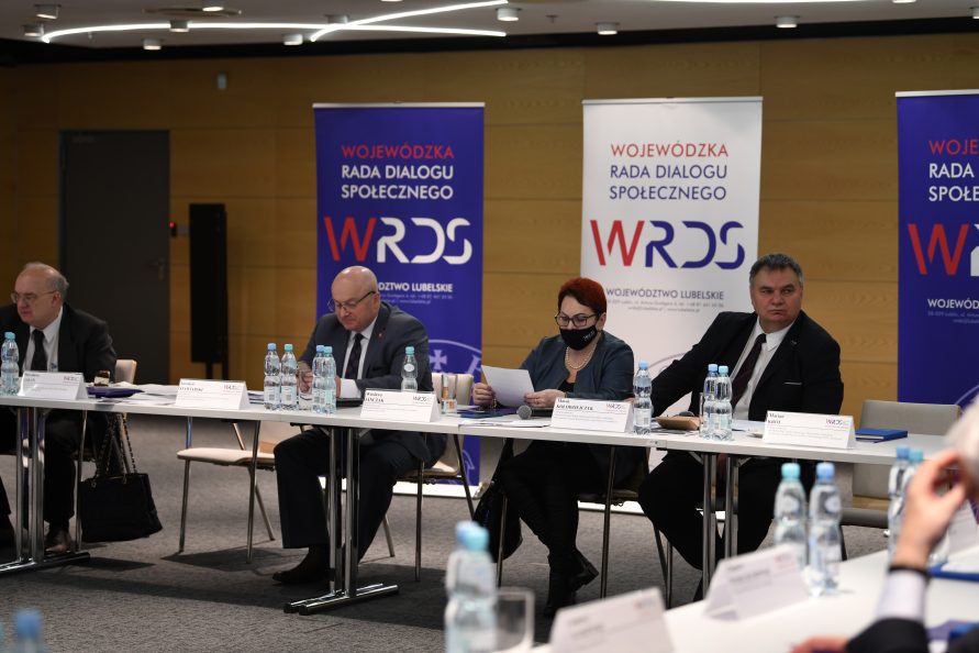 Zdjęcie przedstawia trzy osobe siedzące przy stole, dwóch mężczyzn i jedną kobietę