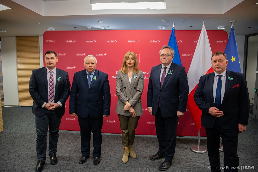 na zdjęciu widocznych jest czterech meżczyzn i jedna kobieta, wszyscy stoją obok siebie pozując do zdjecia