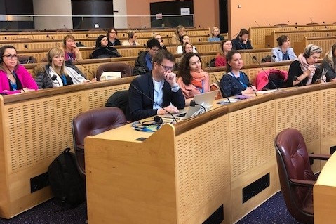 Grupa osób siedząca w sali wykładowej