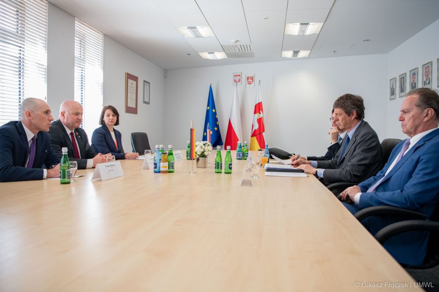 Sześć osób siedzi i rozmawia przy stole