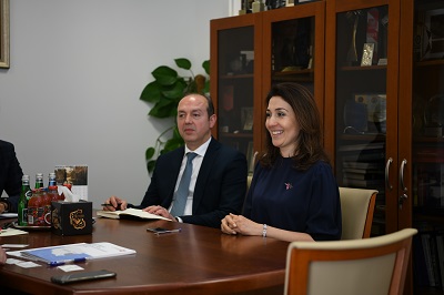 Mężczyzna w okularach i usmiechnięta kobieta siedzą przy stole.