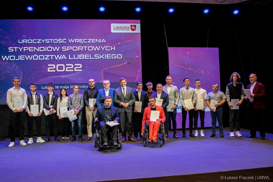 Grupa stypendystów młodych ludzi stojąca na scenie