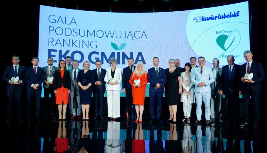 Laureaci rankingu EKOgmin "Kuriera Lubelskiego" na scenie. Za nimi w tle ekran z napisem "GALA PODSUMOWUJĄCA RANKING EKOGMINA"