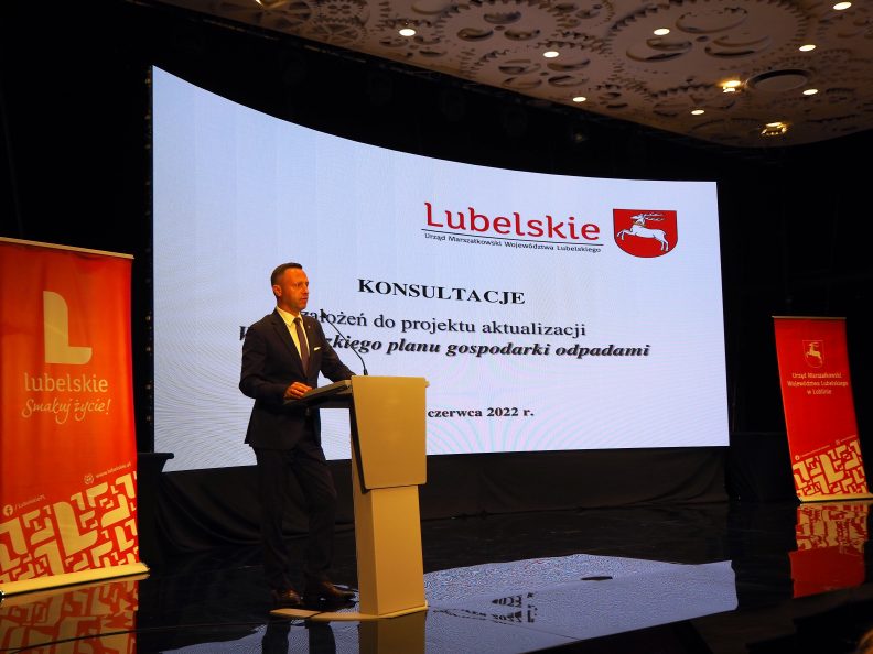 Wicemarszałek na scenie przy ekranie z nazwą spotkania. Obok rollupy