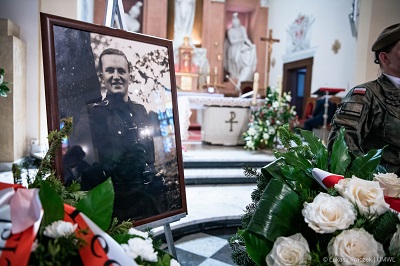 Widok na wnętrze kościoła w trakcie trwania mszy pogrzebowej. Po lewej stronie na sztaludze jest ustawione zdjęcie zmarłego - żołnierza AK