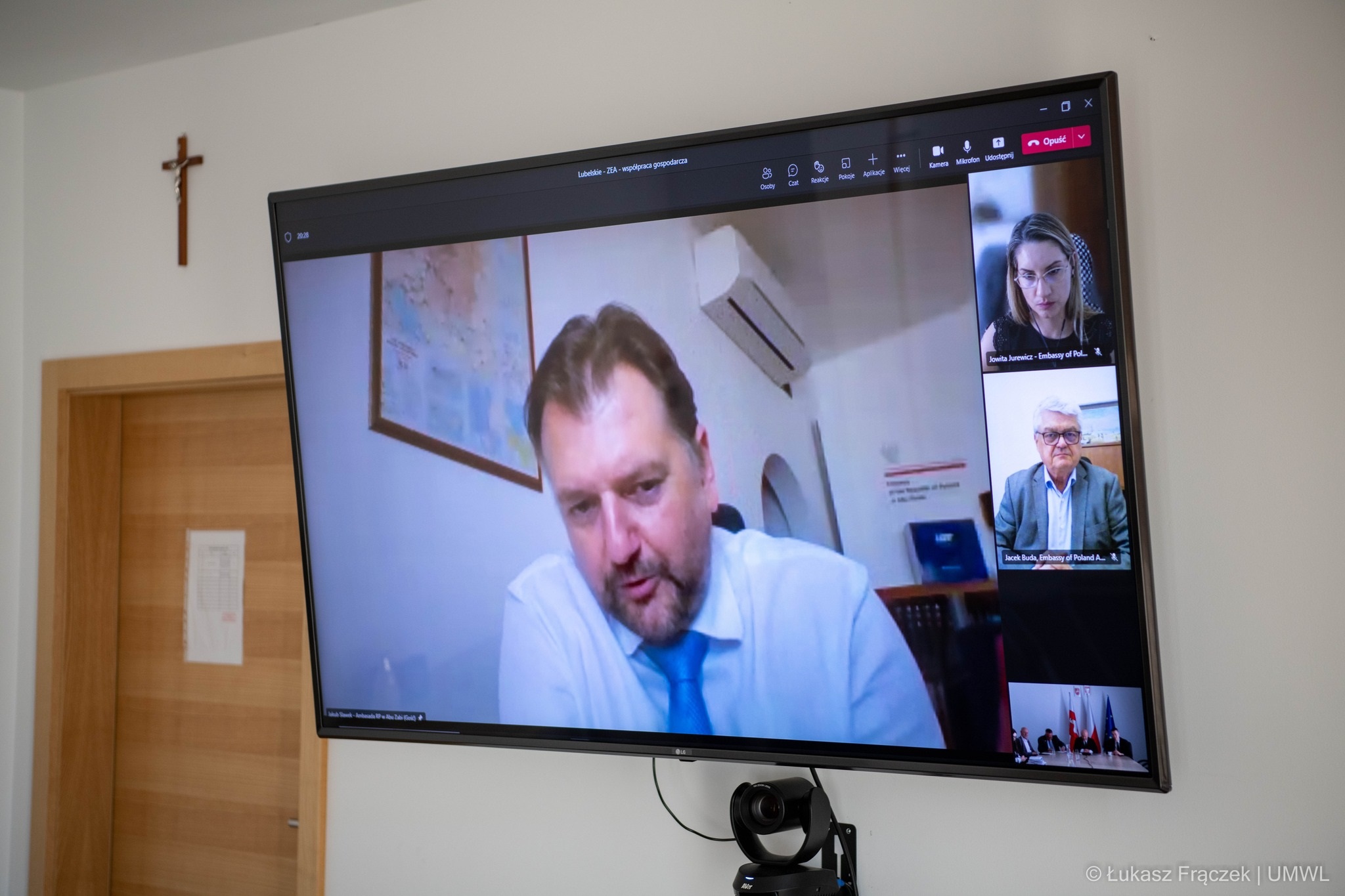 Ekran telewizora na którym wyświetlają się uczestniczy wideokonferencji.