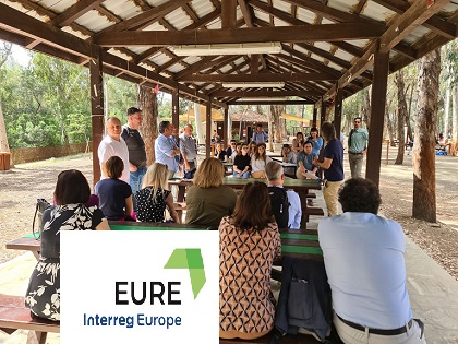 grupa ludzi siedzacych pod wiatą w parku oraz logo projektu EURE
