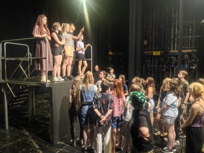 Grupa młodzieży na scenie w teatrze w trakcie warsztatów