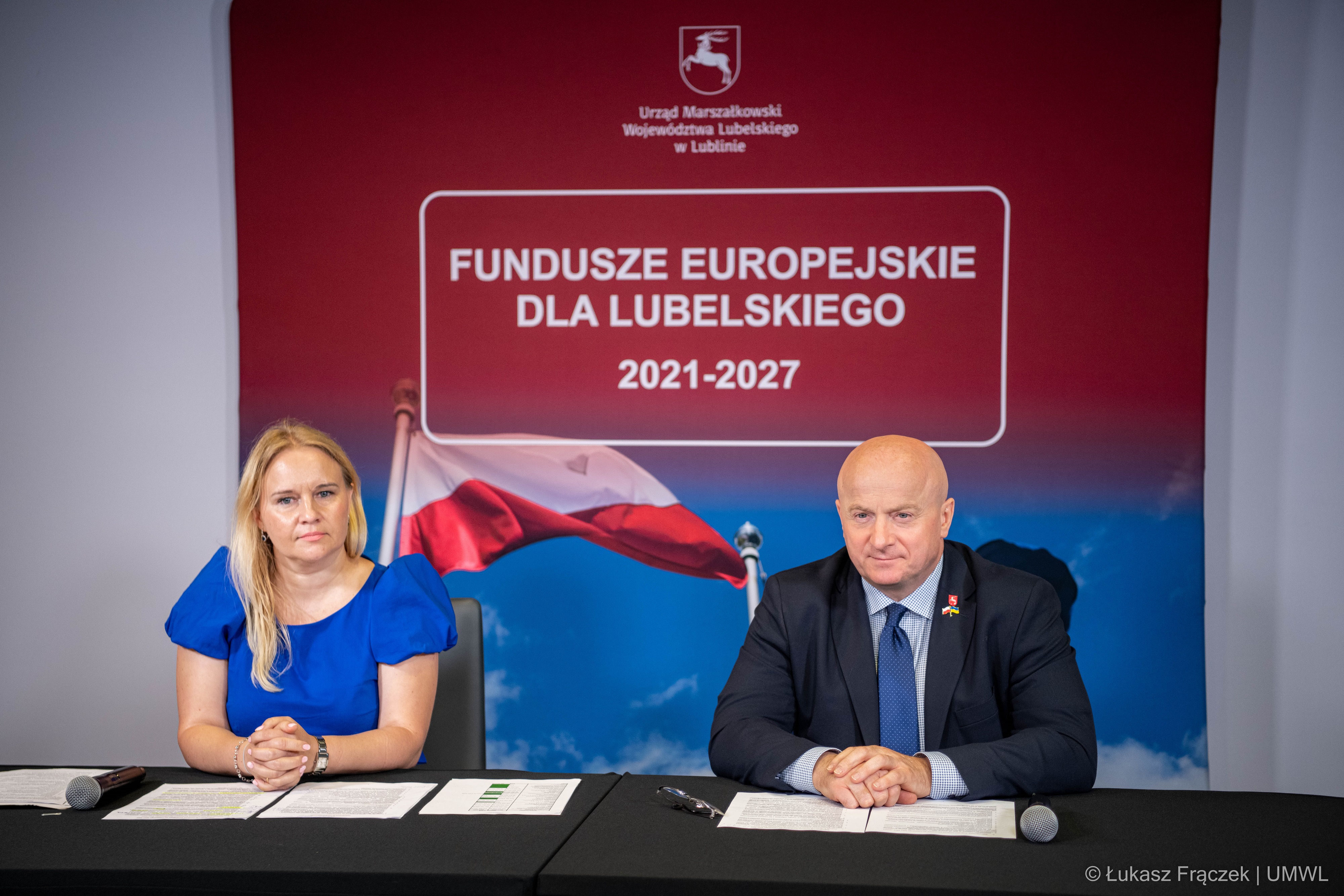 Kobieta i mężczyzna siedzą przy stole za nimi napis fundusze europejskie dla Lubelskiego 2021-2027