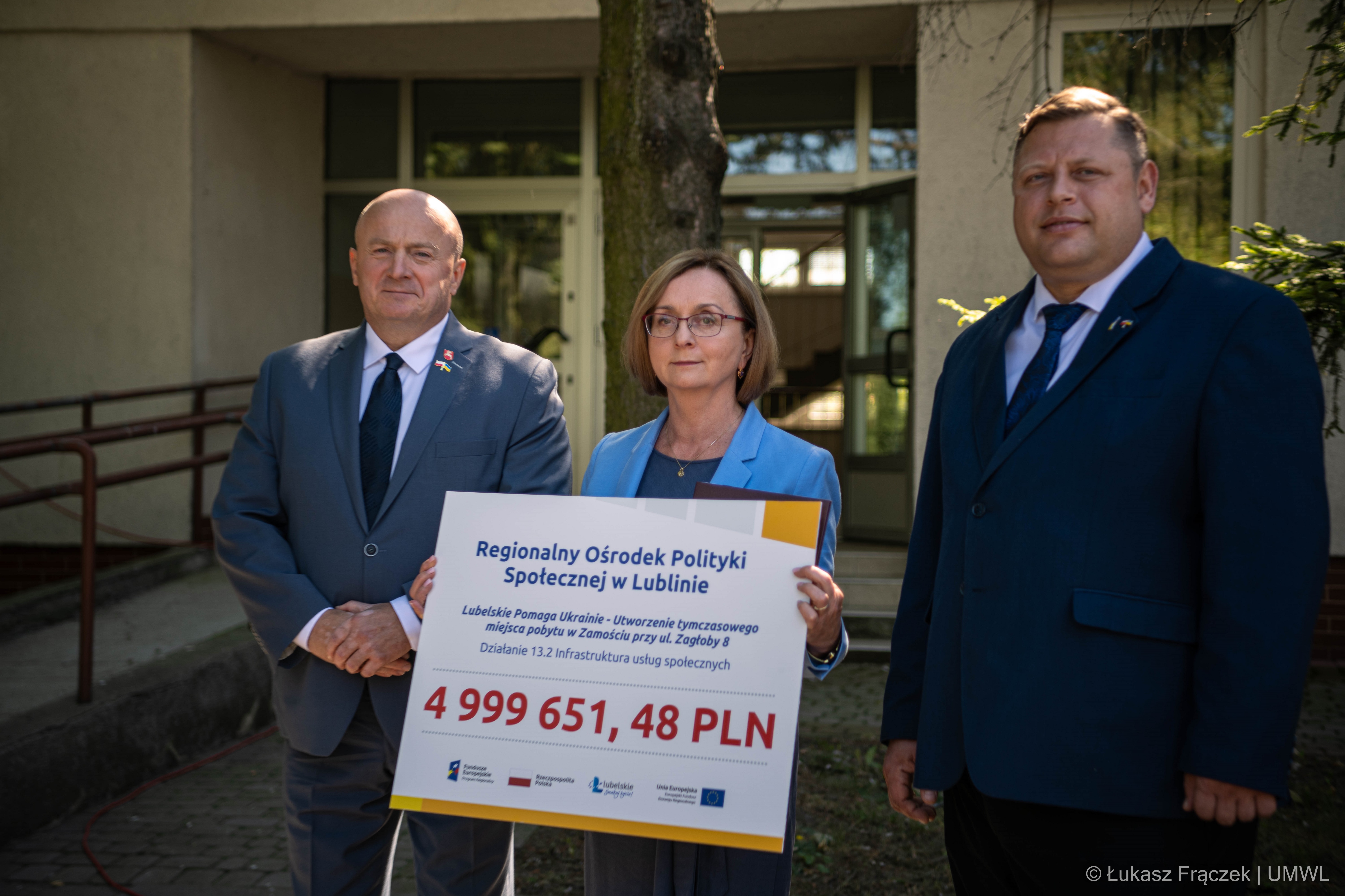 Marszałek Województwa Lubelskiego, Dyrektor ROPS i Konsul Ukrainy pozują do zdjęcia z symboliczną planszą zaiwerająca informację o uzyskanej dotacji