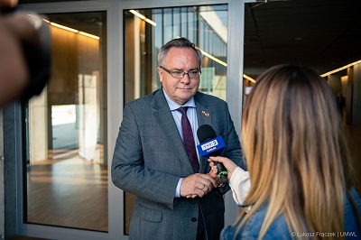 Wicemarszałek WL udziela wypowiedzi dziennikarce na zewnątrz budynku LPNT