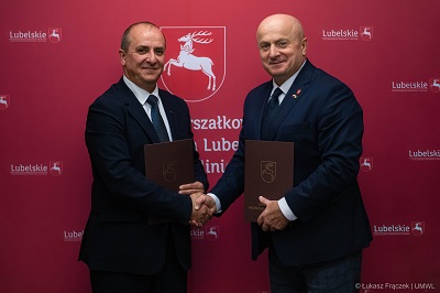 Marszałek WL i dyrektor Muzeum Badań Polarnych podają sobie ręce. Obaj trzymają w rękach teczki z podpisaną umową