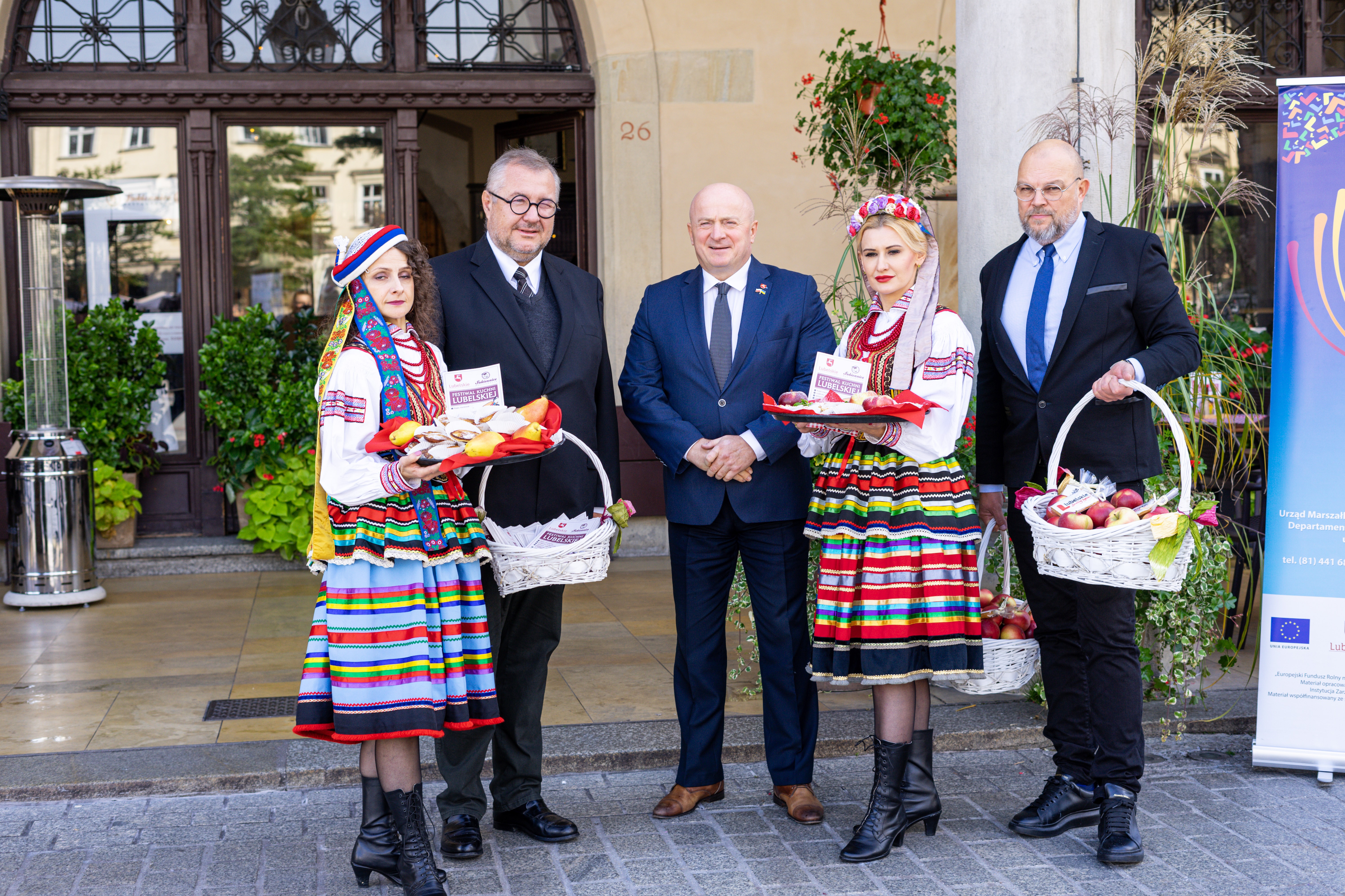 Grupa uczestnickow konferencji kobiety i mężczyżni siedzacych przy stole, za nimi scianka Uniwersytety Medycznego