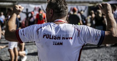 Mężczyzna stojący tyłem do aparatu ma na koszulce napis Polish Run