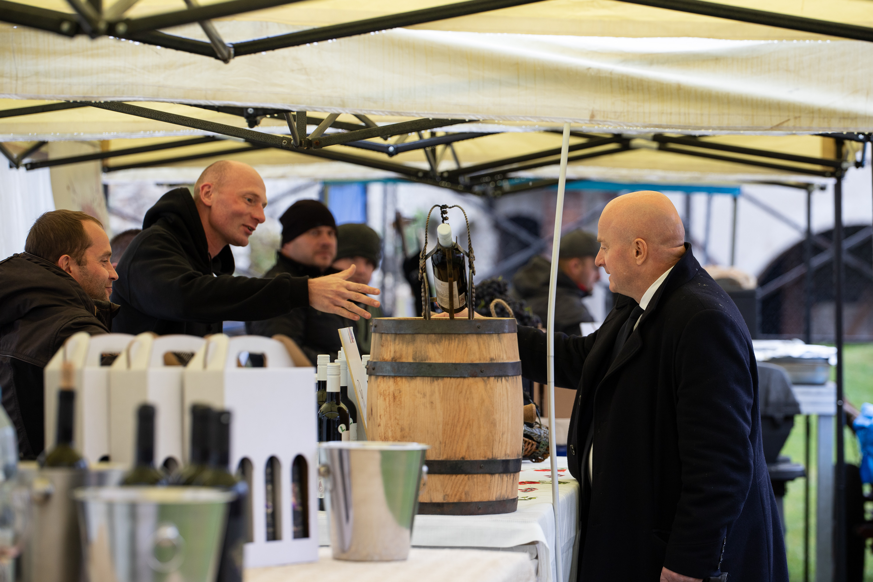 Marszałek WL przy stoisku z kadzią z winem, słucha informacji, których udziela mu wystawca