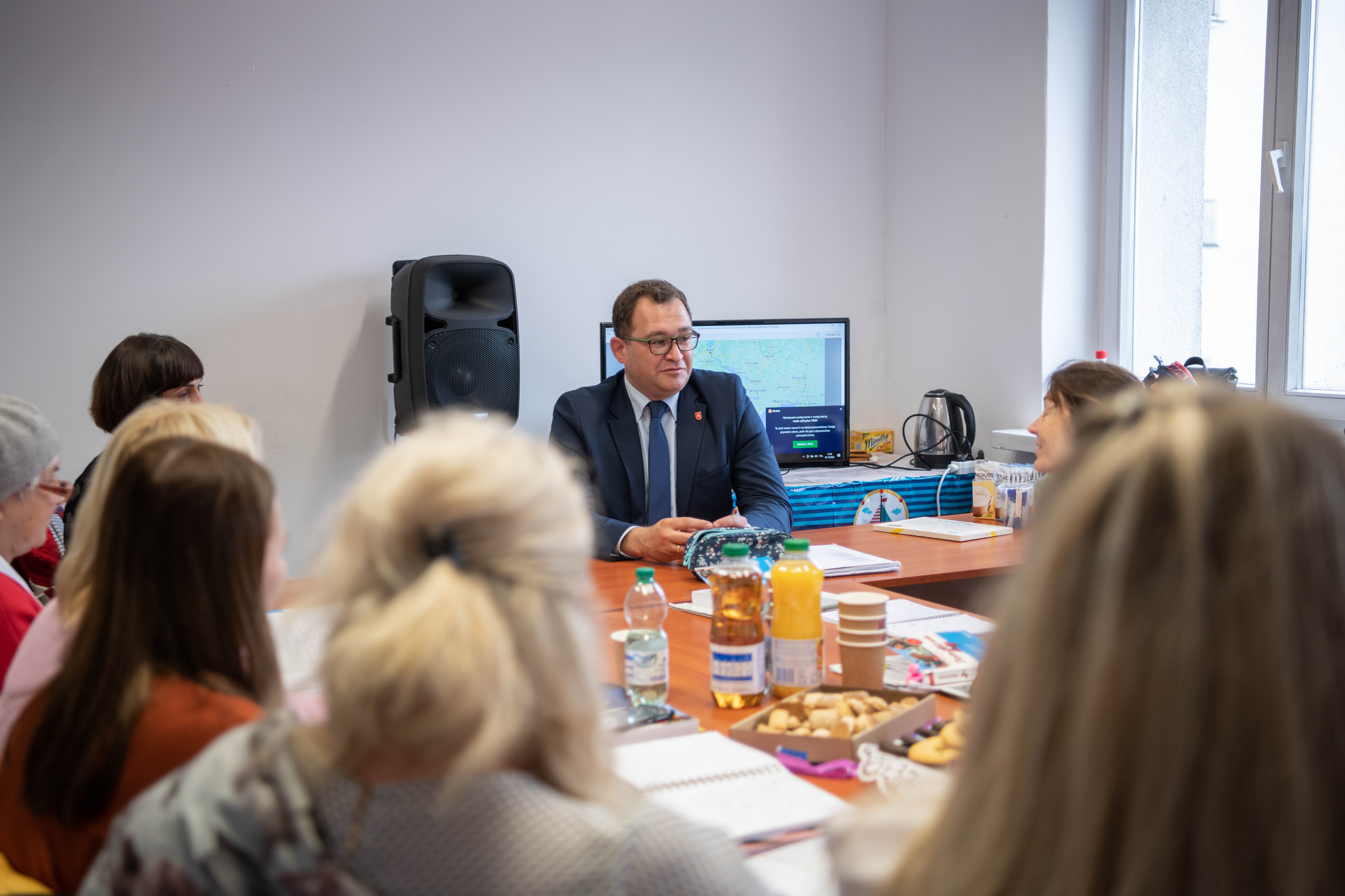 czlonek zaządu b. Bałaban siedzi w sali lekcyjnej i rozmawia z uczestniczkami kursu.