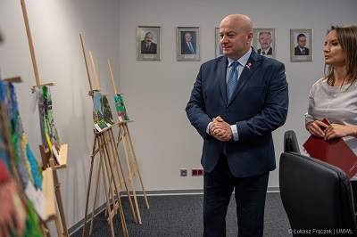 Marszałek WL przeglada prace plastyczne dzieci umieszczone na sztalugach