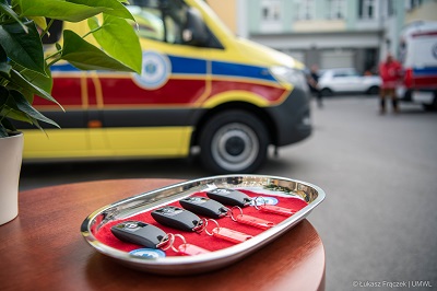 Stolik z kluczami do karetek, w tle karetka