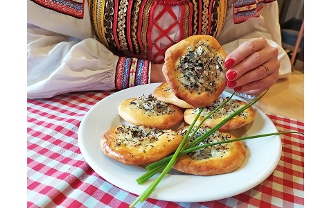 kobieca dłoń sięga po cebularze ułożone na talerzu