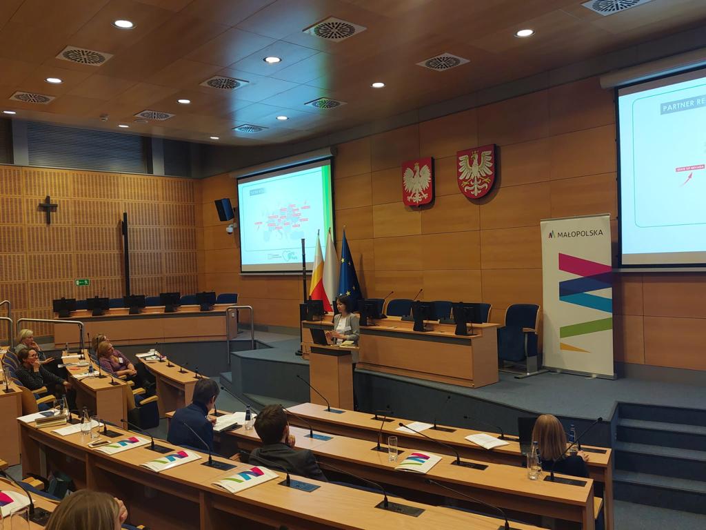 Sala wykładowa z ekranem wyświetlającym prezentację