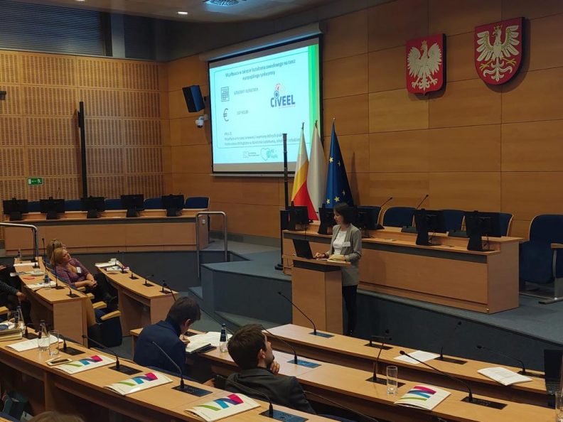 Sala wykładowa z ekranem wyświetlającym prezentację