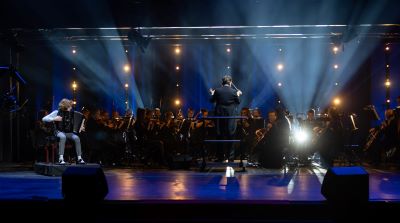 orkiestra i młody akordeonista na scenie
