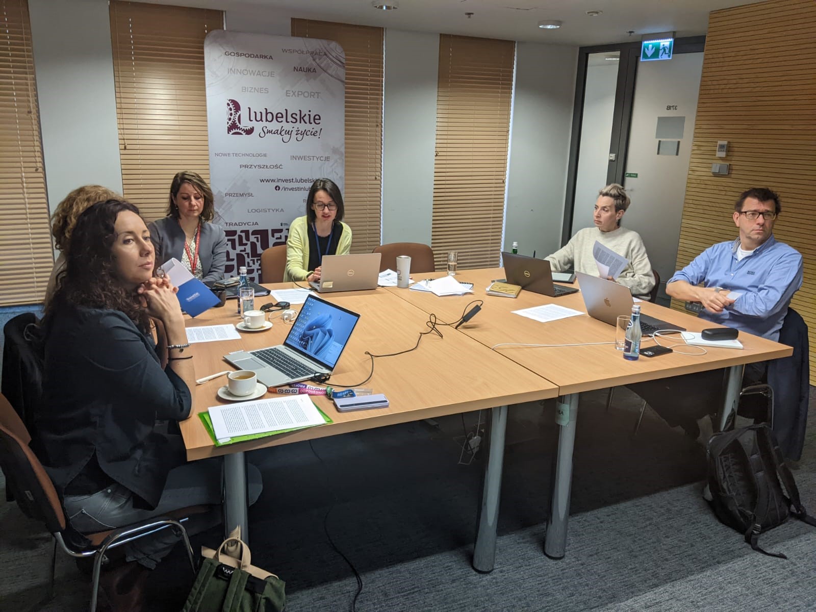 Widok na ekran z prezentacją i salę pełną uczestników wykładu