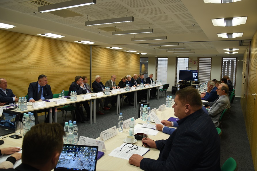 Członkowie WRDS prowadzą debatę siedząc przy stole ustawionym w podkowę