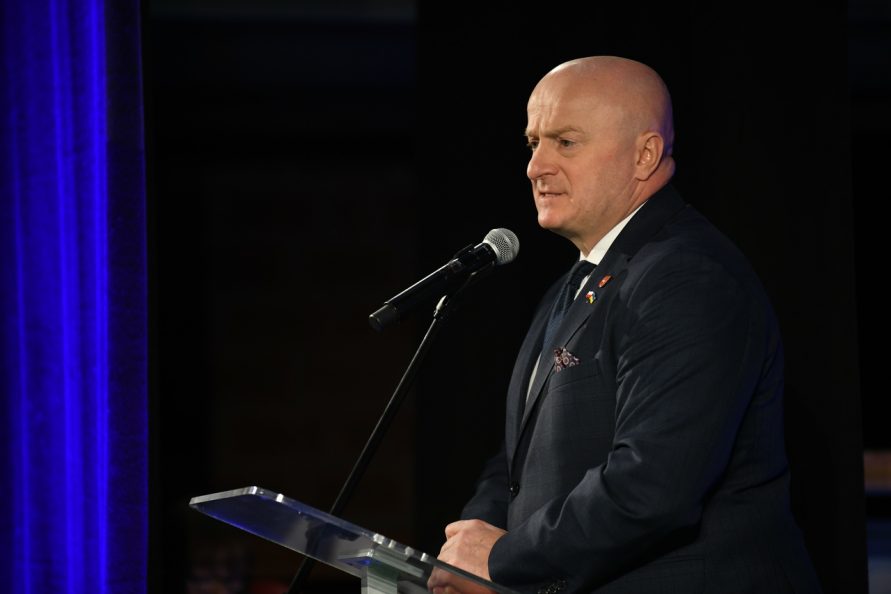 Marszałek Jarosław Stawiarski przy pulpicie otwiera konferencję dot. centrów usług społecznych