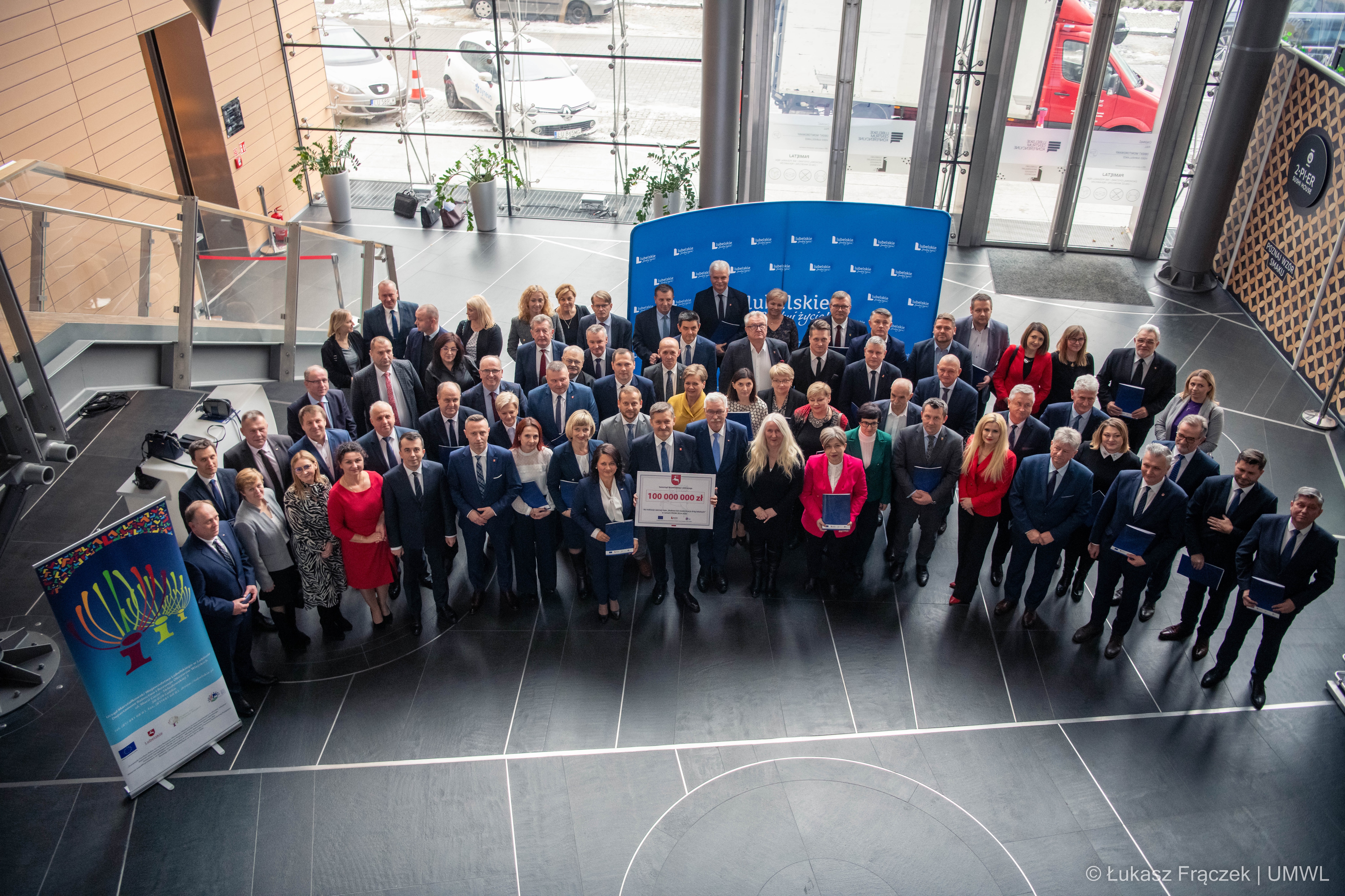 Przedstawiciele nagrodzonych gmin pozują do zdjęcia w holu LCK