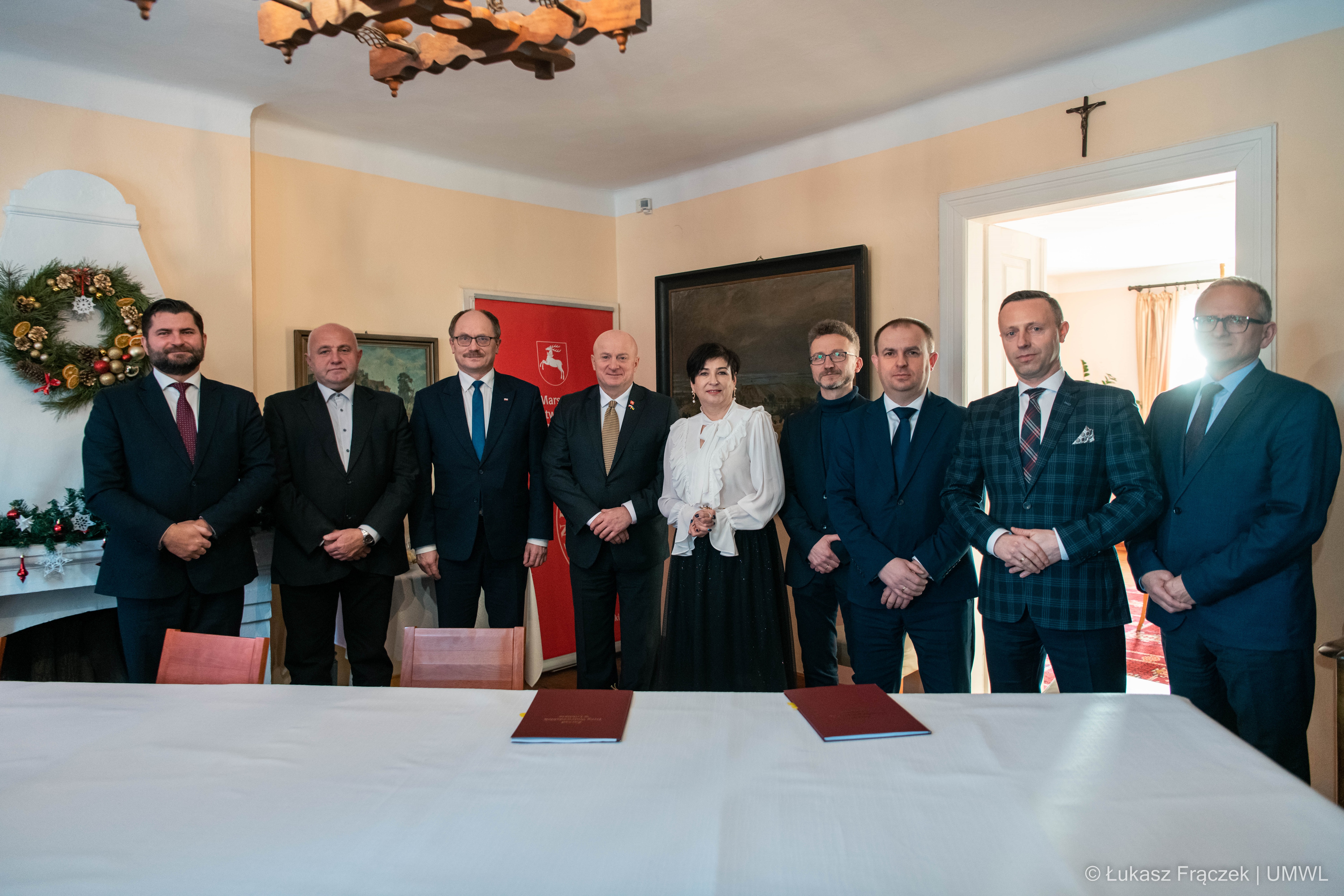 Uczestnicy spotkania przy Zamku w Janowcu, wspólnie pozują do zdjęcia, wśród nich znajdują się członkowie Zarządu Województwa Lubelskiego