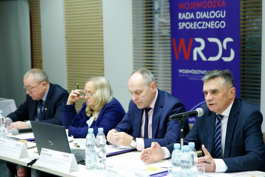 Widok na stół prezydialny w trakcie posiedzenia plenarnego. Siedzący przy nim Wojewoda Lubelski udziela wypowiedzi.