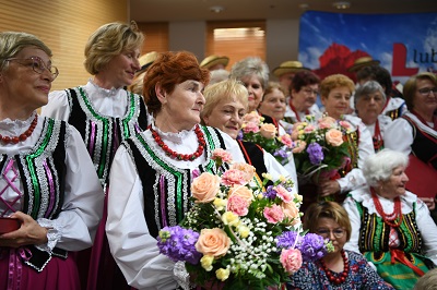Panie z Koła Gospodyń Wiejskich w strojach ludowych i z kwiatami