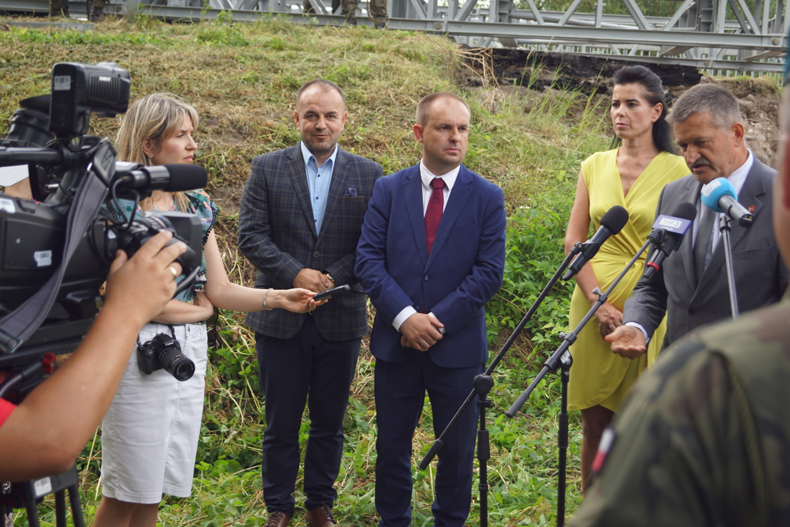 Uczestnicy otwarcia budowy mosty podczas konferencji na świeżym powietrzu, wśród nich członek zarządu